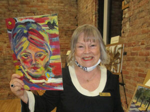Women smiling while holding painting