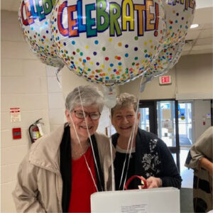 A couple of women holding balloons