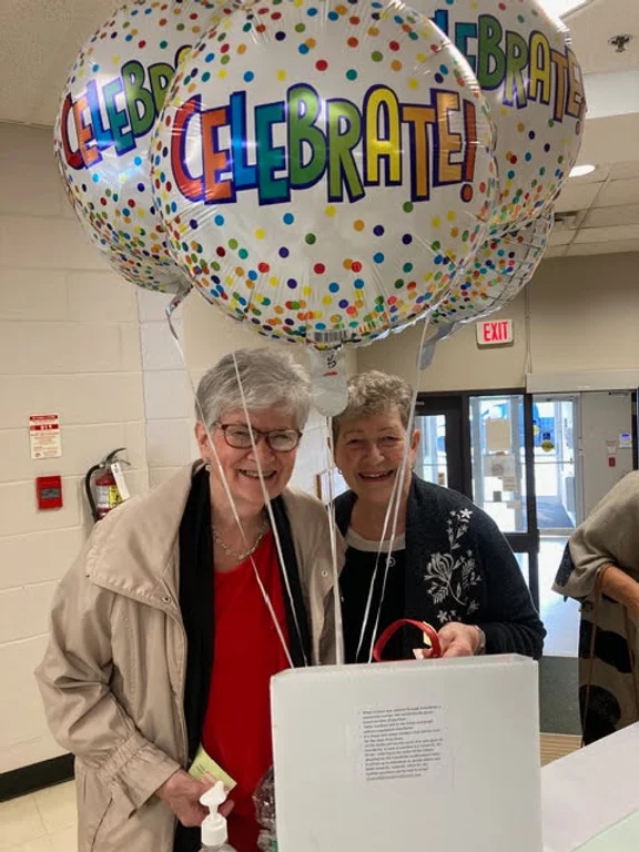 A couple of women holding balloons